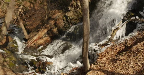 Waterfall in spring time with icicles on the rocks Stockbeeldmateriaal 60951556