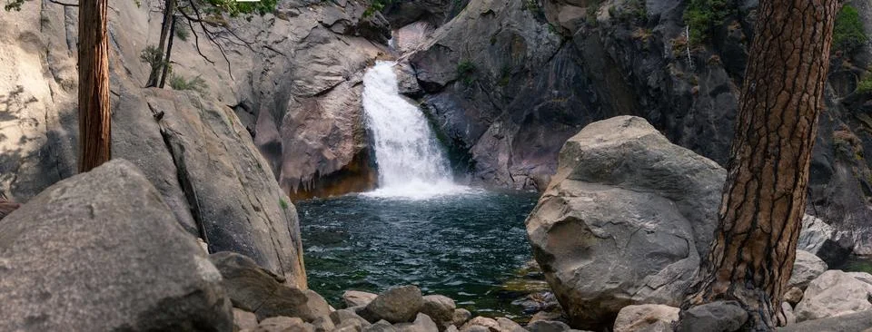 Waterfall in stone walls fall down to natural pool with clear water in nati.. Stock Photos