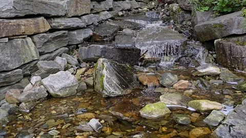 Waterfall stream flowing in gentle tiers over grey and orange granite rocks Stock-Footage 345168177