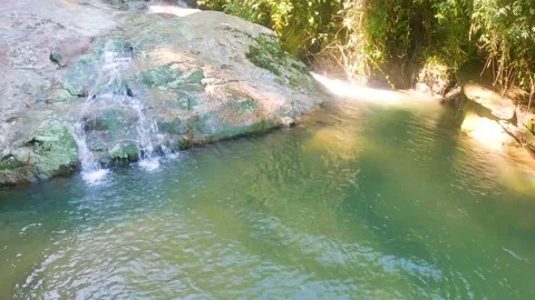 Waterfall stream running fast over big rock Stock Footage 168704804