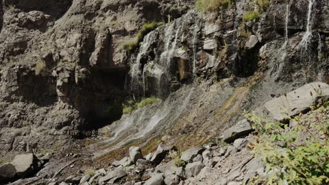 Waterfall streaming down rocky cliff face in Colorado Video stock 348023549