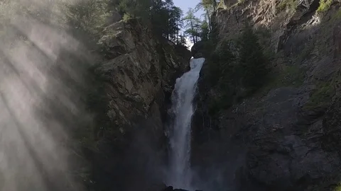 Waterfall with sun rays whimsical mountain landscape Stock Footage 128304971