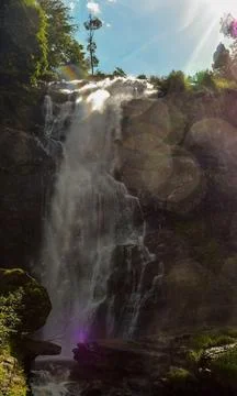 Waterfall with sun reflection Stock Photos