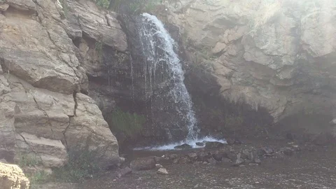 Waterfall surrounded by a rocky landscape Stock Footage 98678813