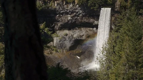 Waterfall with tiny rainbow flare on a sunny day Stock Footage 124899894