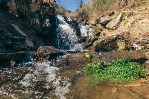 A waterfall with trees on the side of a mountain Stock Photos