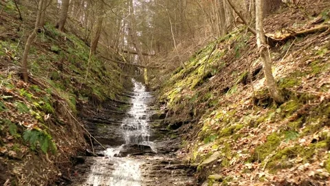 Waterfall trickles down mountain side during Spring season in New York State Stock Footage 182944348