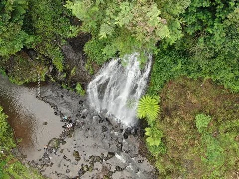 Waterfall on tropical mountain, Java, Indonesia. Stock Photos