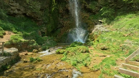 Waterfall tumbles down mossy cliffside. Gostilje, Serbia. Slowmotion Stock Footage 337061564