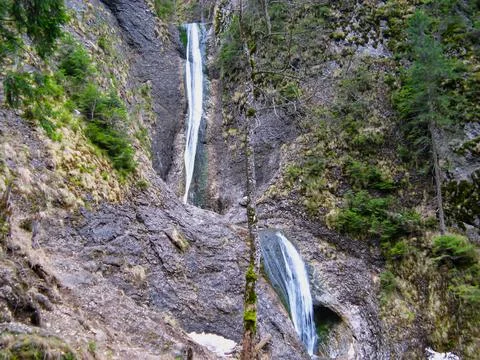 A waterfall on two levels surrounded by forest Stock Photos