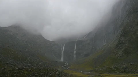 Waterfall under mist and rain, in Milford Sound, New Zealand Stock Footage 219228638