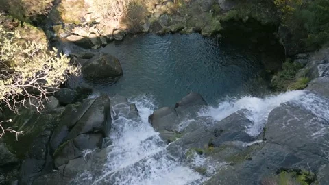 Waterfall view from above tilt down moving forward revealing a pond Stock Footage 237767606