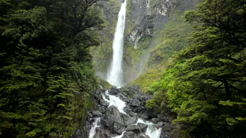 Waterfall view panning from top to bottom through green gorge Stock Footage 326505854