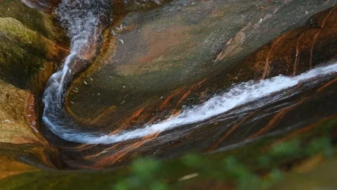 Waterfall, viewed from the side, cascading down a smooth slippery rock face Stock Footage 107174458