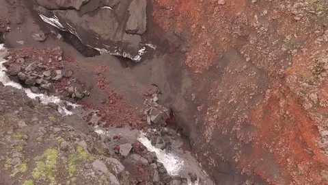 Waterfall in Volcano. Mountain river flows into a waterfall. red soil Stock Footage 72655774