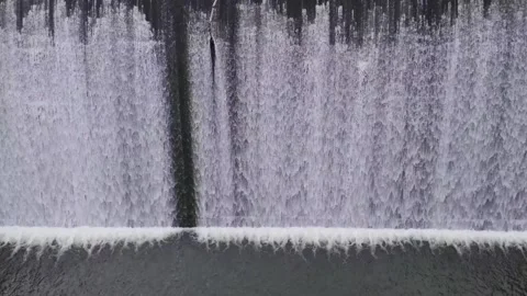 Waterfall wall cascading down dam structure in cinematic slow motion footage. Stock Footage 333830407