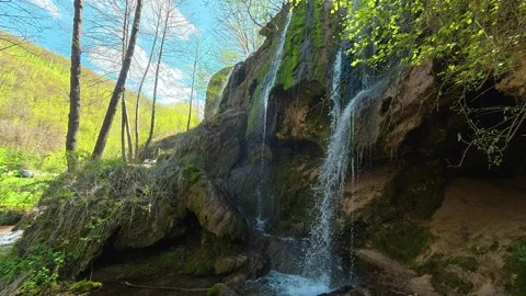 Waterfalls cascade down mossy rock faces. Balkan, Eastern Europe, POV Video stock 333587214