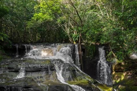 Waterfalls cascading down rocks into Amazon River surrounded by rainforest Stock Photos
