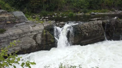 Waterfalls flowing into a raging river Stock Footage 138650755