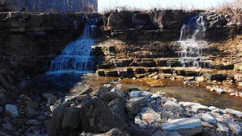 Waterfalls flowing into a small stream Stock Footage 98614535