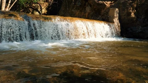 Waterfalls in the forest with rocks and tree branches. Mud and river with rocks Stock Footage 105412247