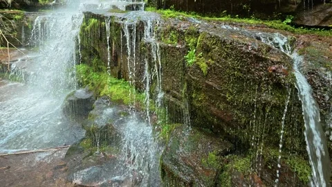 Waterfalls tumble down mossy rock faces. Slowmotion. Tupavica Waterfall Video stock 335536102