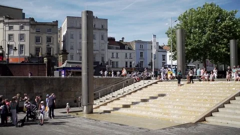 Waterfront bristol slow mo people walking pan sunny Stock Footage 69773653