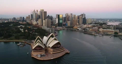 Waterfront buildings of Sydney CBD at Circular quay across harbour at sunrise. Stock Footage 136060558