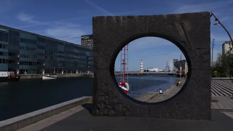 Waterfront view of stone sculpture and lighthouse in Malmo harbor, Sweden Stock Footage 340960274