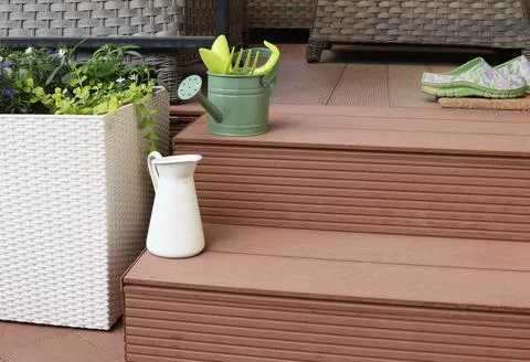 Watering can on backyard. Tools for flowers in garden. Deck steps on patio Stock Photos