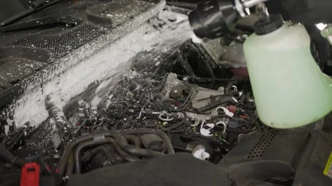 Watering car engine compartment with foam from a hand sprayer. Video stock 248117430