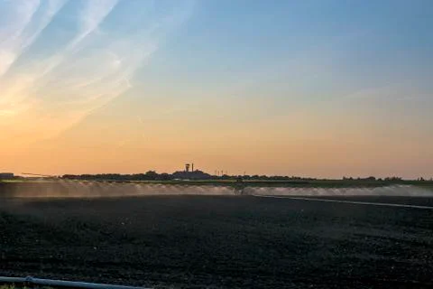 Watering the fields at dusk Stock Photos
