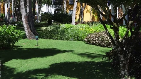 Watering the grass.View of the beautiful hotel grounds on a sunny day. Stock Footage 204720925