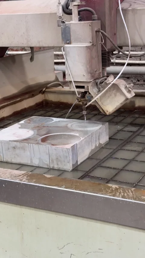 Waterjet cutting machine slicing through a thick metal plate, with a high?pre 動画素材 325649017