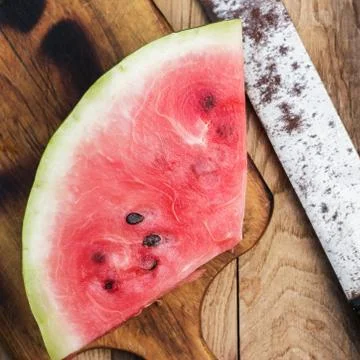 Watermelon and old knife on the table Stock Photos