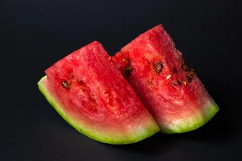 Watermelon on a black background. Cut off a slice of watermelon. Stock Photos