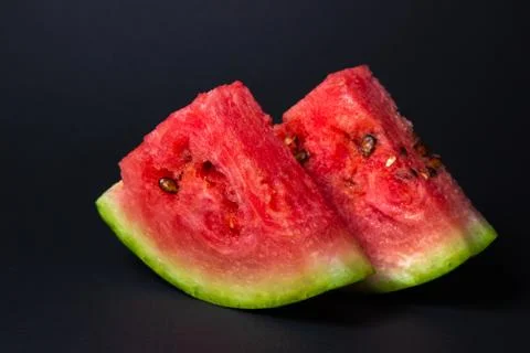 Watermelon on a black background. Cut off a slice of watermelon. Stock Photos