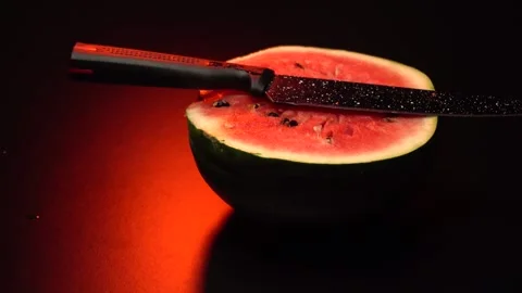 A watermelon cut in two halves with a knife Stockbeeldmateriaal 283731826
