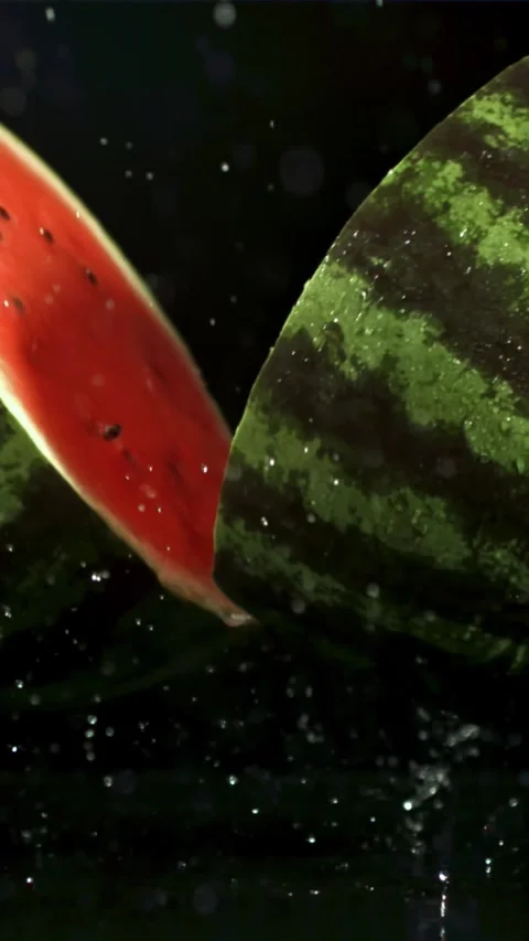 The watermelon falls on the table and splits in half. Filmed on a high-speed Video stock 335318032