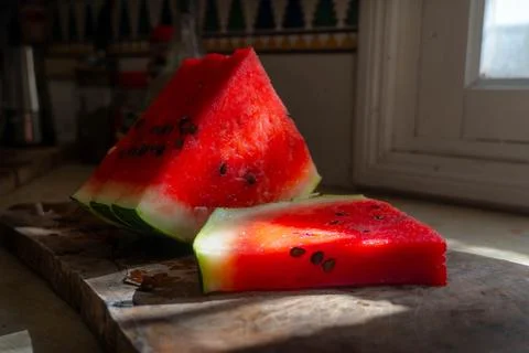 The watermelon on the kitchen table, lightened by the sunlight. Stock Photos