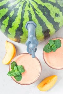 Watermelon, peach, mint and coconut milk smoothie in glass on white wooden ba Foto stock