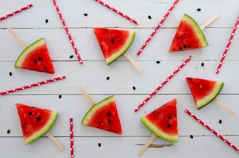 Watermelon red slice popsicles and juice straw on a white rustic wood background Stock Photos