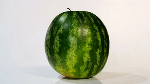 Watermelon rotates on a white stand on a white background Stock Footage 137948701