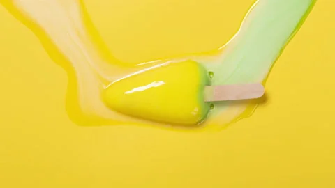 Watermelon shape popsicle melting timelapse on yellow background at top angle Stock Footage 201738543