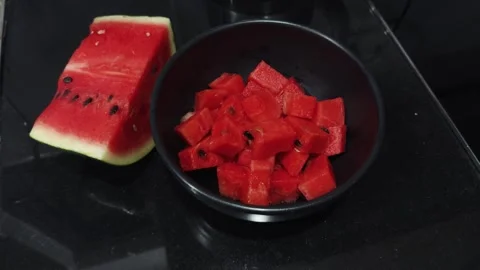 Watermelon slice and diced fruit in a bowl, offering a refreshing, juicy, and Stock Footage 345515585