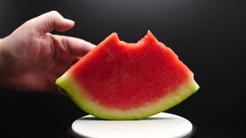 Watermelon slice with a bite in it falling in slow motion being pushed over Video stock 205330552