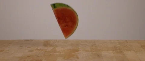 A Watermelon Slice Falling Onto Cutting Board In Slow Motion 스톡 동영상 105376927