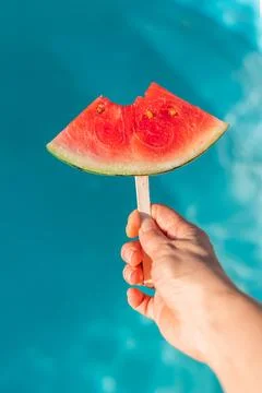 Watermelon Slice Held Above Pool Water Stock Photos