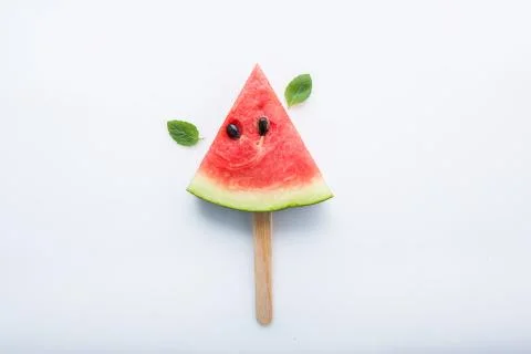 Watermelon slice popsicles and paper mint on white wooden background. Stock Photos