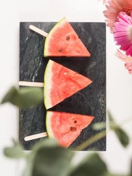 Watermelon slice popsicles on marble tray Stock Photos